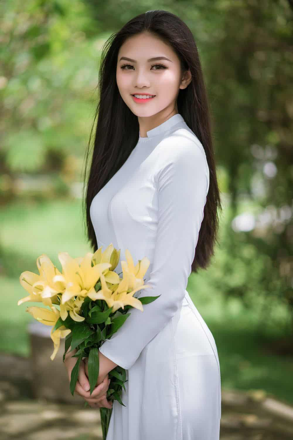 Hình ảnh cô gái xinh đẹp trong tà áo dài và hoa